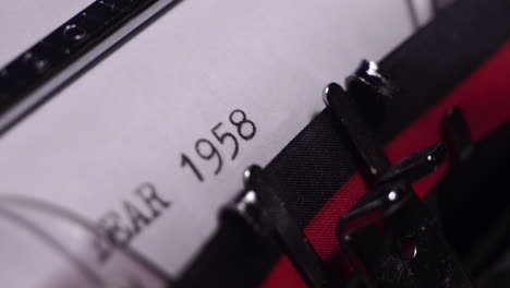 year 1958, typing on white paper in vintage typewriter, macro close up