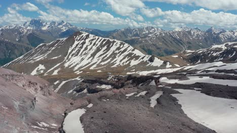 aerial panoramic view of stunning continuous mountain range partially covered with snow