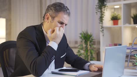 stressed mature businessman nervously working on laptop.