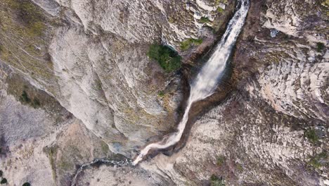 Aerial-slow-motion-twisting-vertical-down-close-to-a-waterfall-in-Tzoumerka,-Greece