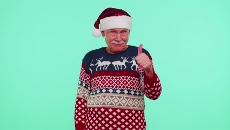 Grandfather-wears-red-New-Year-sweater-with-deers-raises-thumbs-up-agrees-with-something-good,-like