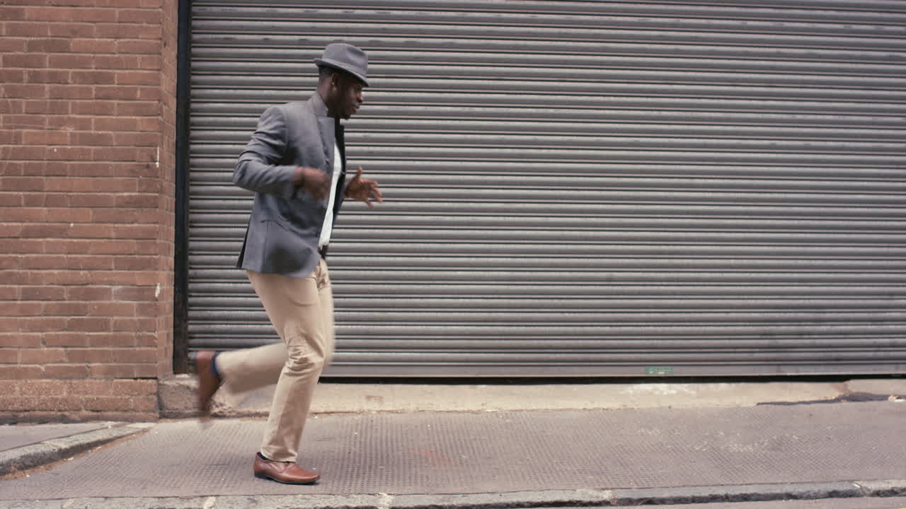 Uomo afroamericano ballerino di strada contemporaneo e funky che balla freestyle in città.