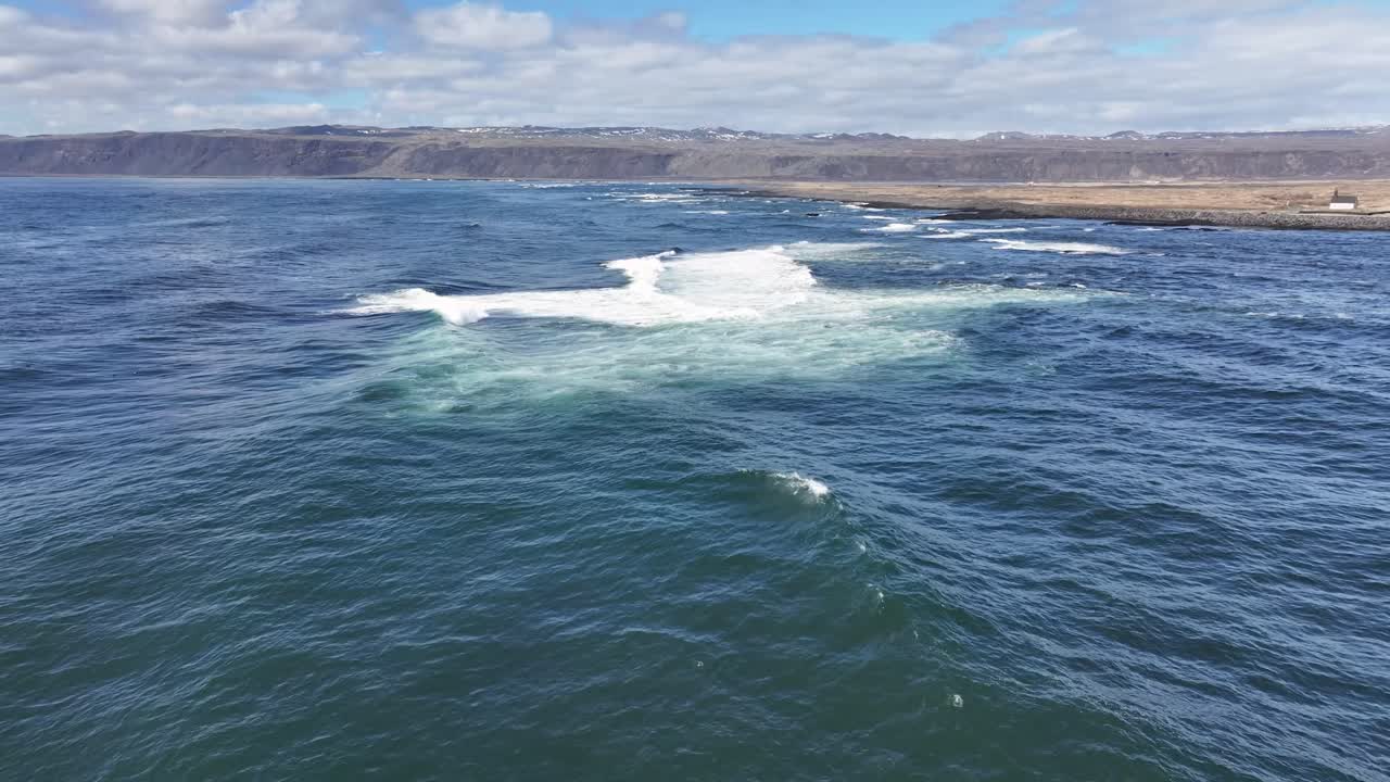 깊은 파란 물과 부드럽게 굴러가는 파도가 있는 바다의 넓은 은 파란 하늘과 함께 비디오에서 볼 수 있습니다.
