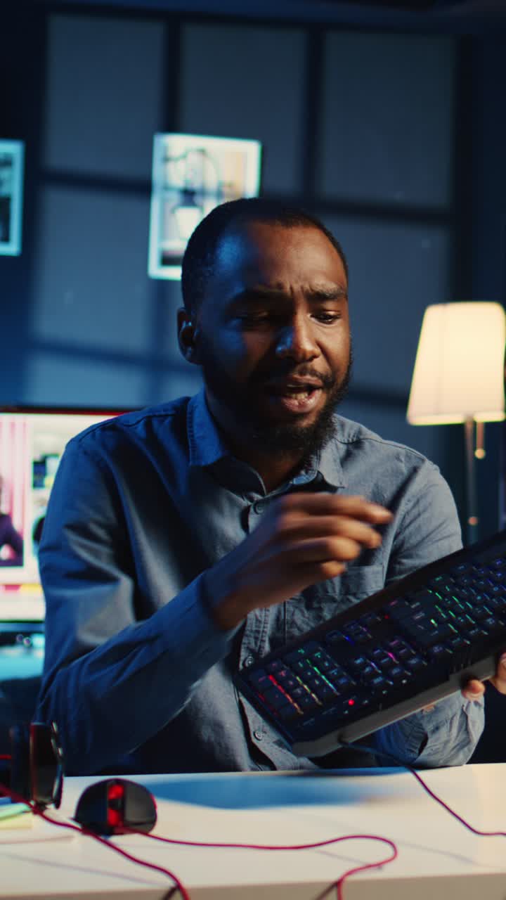 Uomo che recensisce una tastiera in un appartamento studio in un video verticale