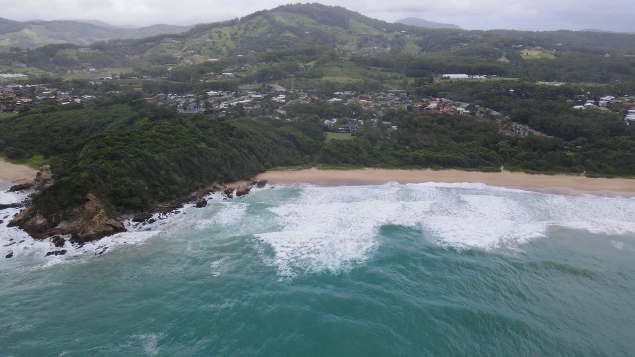 paisaje costero con vegetación exuberante - península de acantilado blanco en la playa de zafiro del sur, puerto de coffs, nueva gales del sur, australia