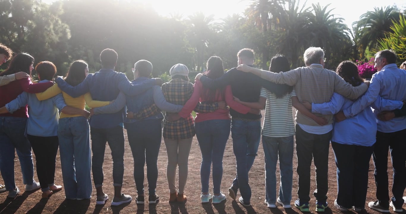 Grupo diverso de personas de pie juntas abrazándose