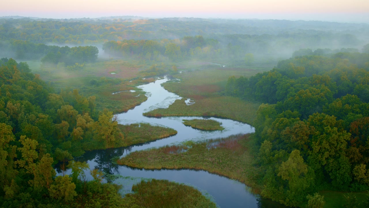 The Huron River blanketed in dawn fog, with a drone capturing Milford, Michigan’s charm.