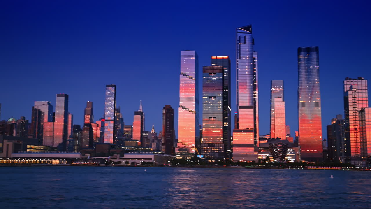Nova Iorque, EUA, 15 de abril de 2026: Horizonte de Manhattan na hora azul sobre o Rio Hudson. Horizonte de Manhattan na hora azul com arranha-céus iluminados refletidos na água do Rio Hudson após o pôr do sol.