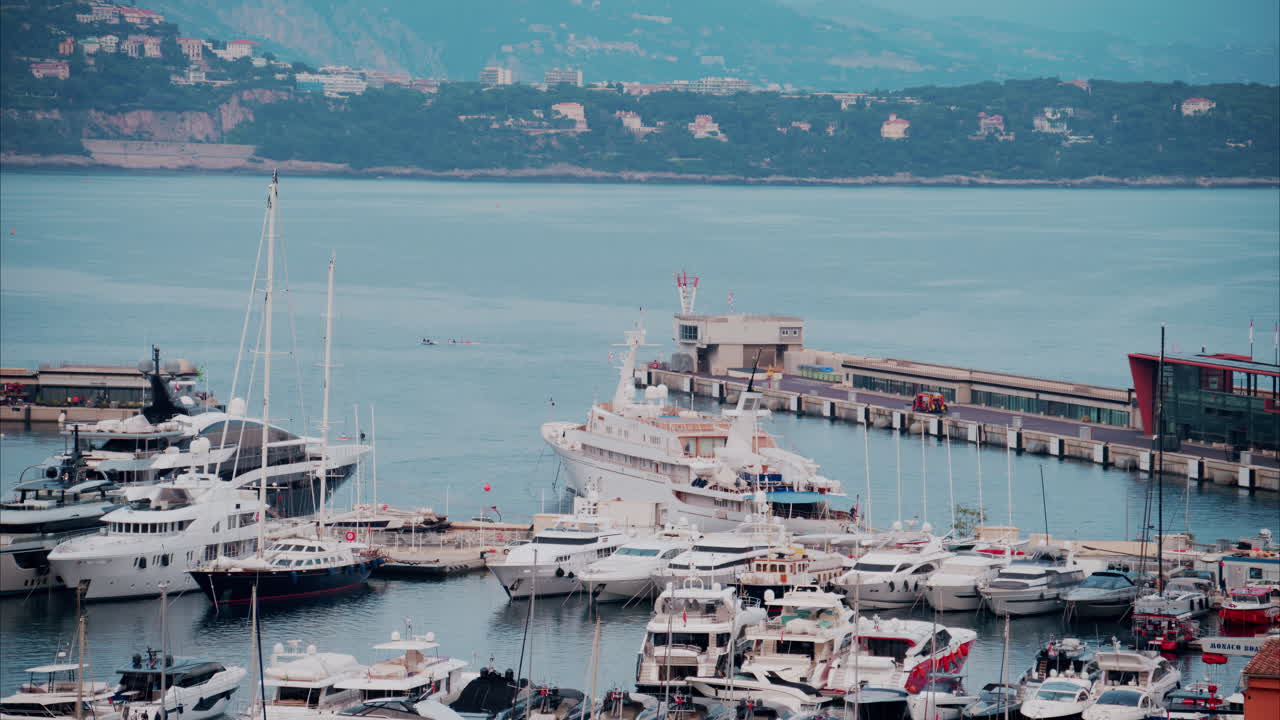 View of boats docked in the Monaco Marina with the skyline of the city on the background