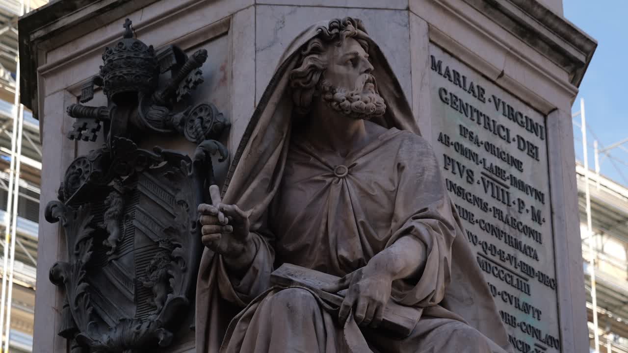 Close-up of an apostle statue from the Column of the Immaculate Conception in Rome, Italy, featuring papal coat of arms and Latin inscription in a religious setting.
