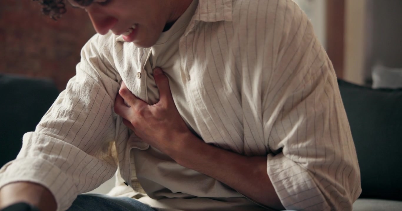 Young Man Experiencing Sudden Chest Pain at Home