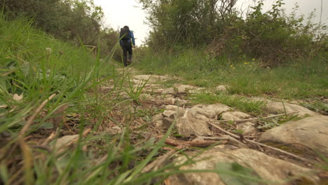 ángulo bajo del hombre caminando en el camino de la montaña, aventura de trekking