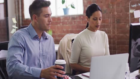 Diverse-male-and-female-business-colleagues-in-discussion-at-work-drinking-coffee