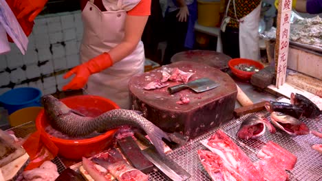 seafood butcher cutting fish in asian seafood wet fish market in hong kong china