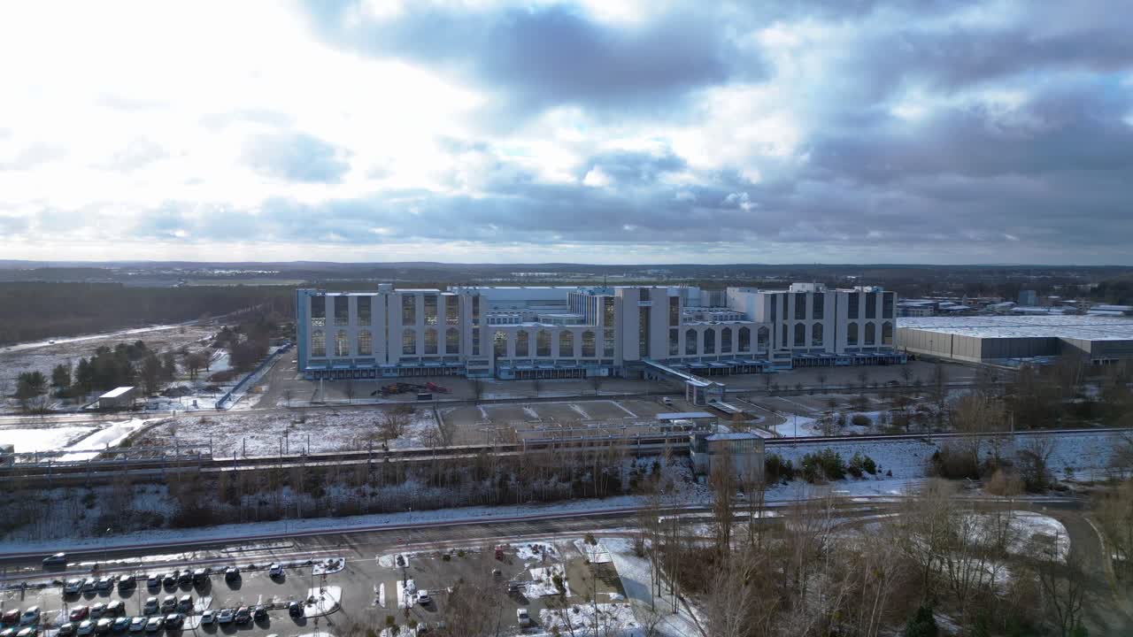 snowy train station with parked cars and surrounding buildings. Lovely aerial view flight static tripod hovering drone