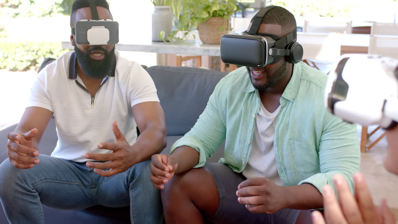 Using VR headsets, diverse friends enjoying virtual reality experience together at home