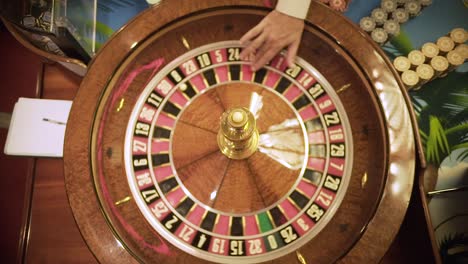 Top-shot-roulette-spinning-in-casino,-close-up-croupier-hands,-luxury-entertainment-,ball-spinning-around