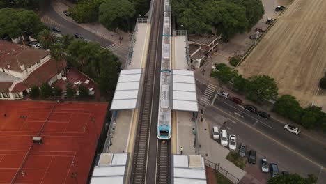 Luftaufnahme-Des-Zuges,-Der-Zum-Modernen-Barrancas-De-Belgrano-Station-In-Buenos-Aires-City-Ankommt