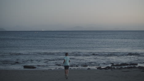 child throwing stones into the ocean black sand beaches of canary islands