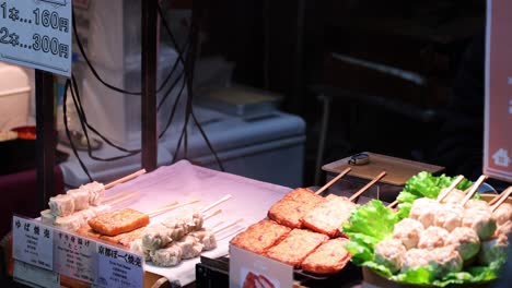 various skewered foods displayed at a street stall