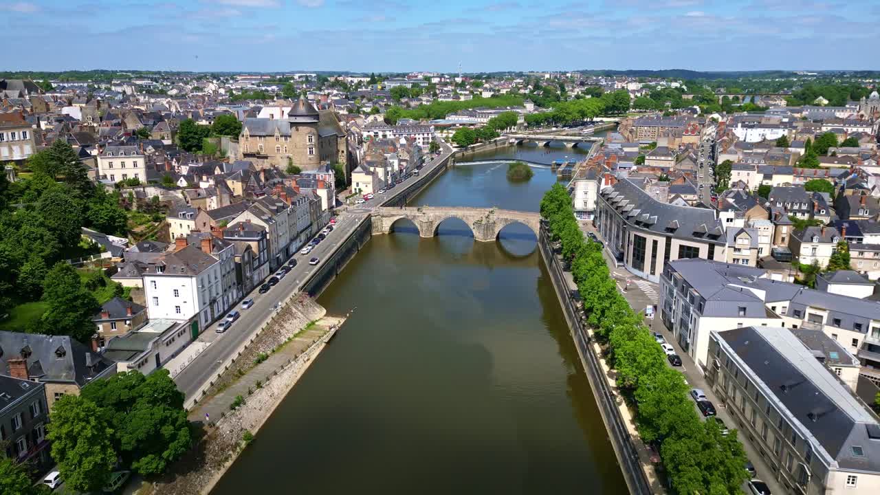 Drone flies forward over Mayenne River, revealing Laval Castle, city center, bridges, and riverbanks - France