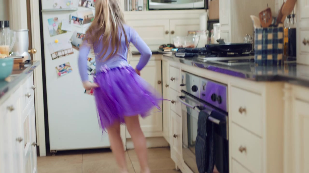 Bambina che Balla in Cucina con un Tutù Viola