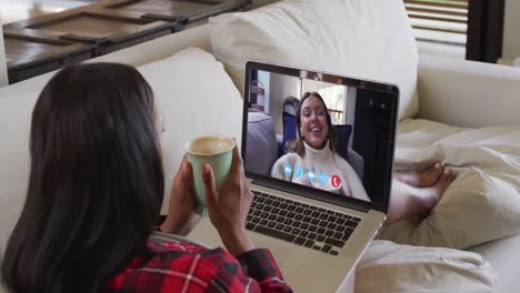 Mixed-race-woman-on-laptop-video-chat-having-coffee-at-home