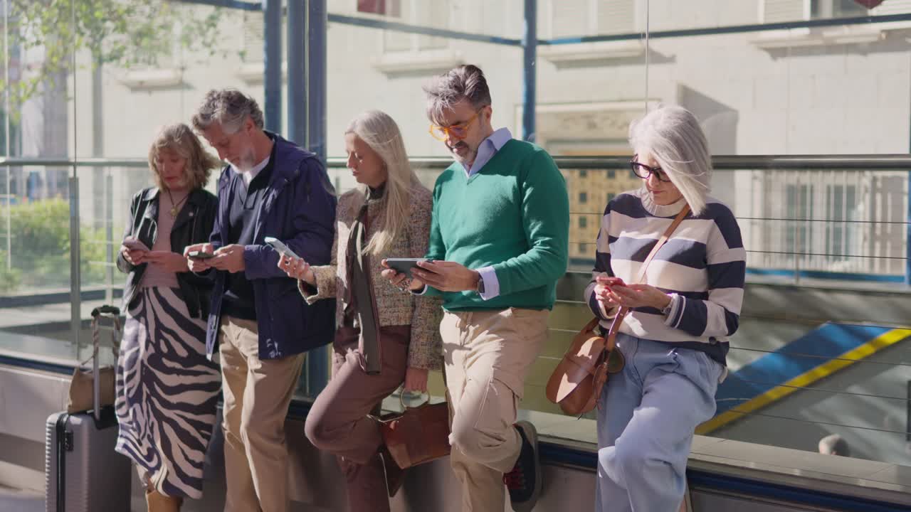 Seniorengruppe beschäftigt sich in der Öffentlichkeit mit Smartphones