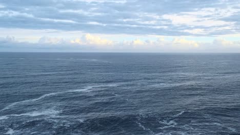 panorama shot of the blue cantabrian sea flowing in one direction on a cloudy day