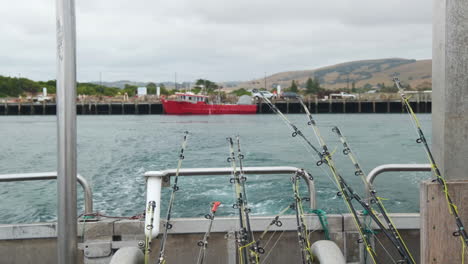 toma estática de un barco de crucero lejos del puerto con muchas cañas de pescar en la proa