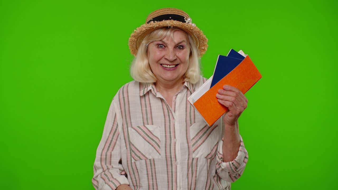 Cestovatelka, starší žena držící pasové jízdenky, sní o tom, do které země se jet rekreovat na dovolenou
