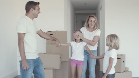 joyful parents and sister leading girl with closed eyes