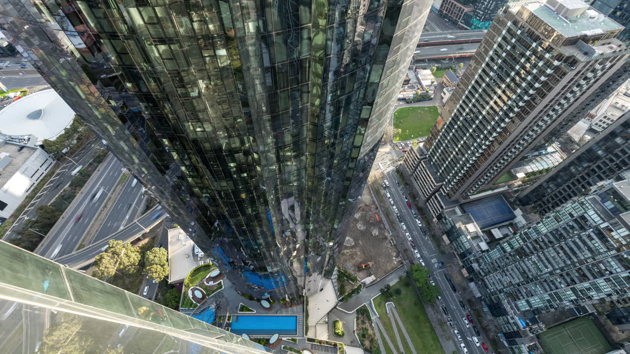 Melbourne freeway and street traffic in time lapse looking down the face of a skyscraper with window reflections