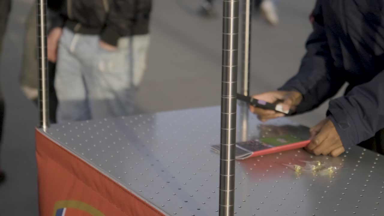 Football fan buys football magazine at stall outside the Emirates Stadium in London