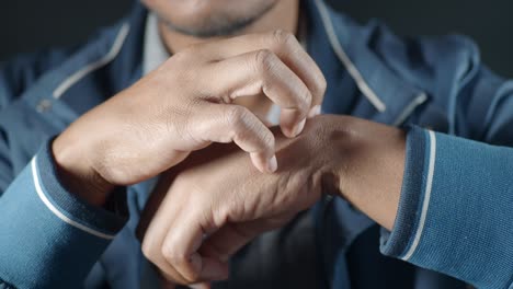 man scratching his wrist