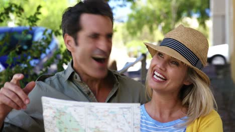 pareja feliz mirando el mapa y señalando