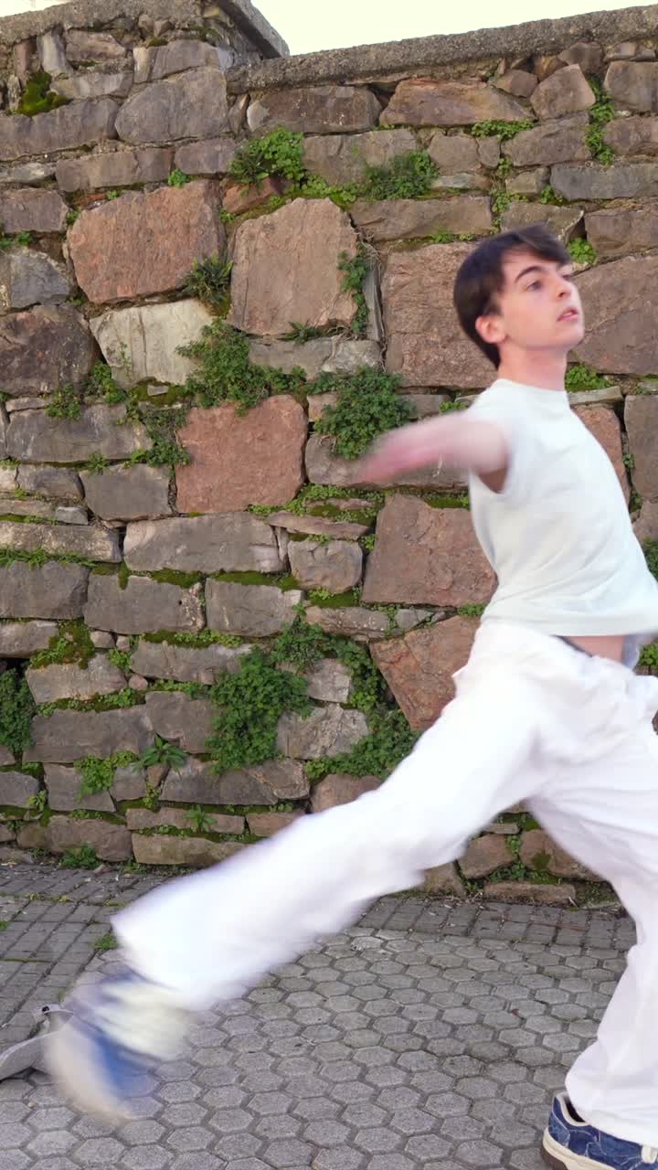Man dancing near a stone wall