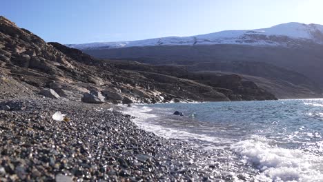 Arctic-Sea-Waves-Breaking-on-Pebble-Beach-on-Coast-on-Greenland-on-Sunny-Summer-Day,-Slow-Motion