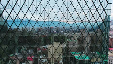 aerial view of the reflection of the city of santiago chile in a giant glass of a diamond-shaped building on a cloudy day, modern architecture