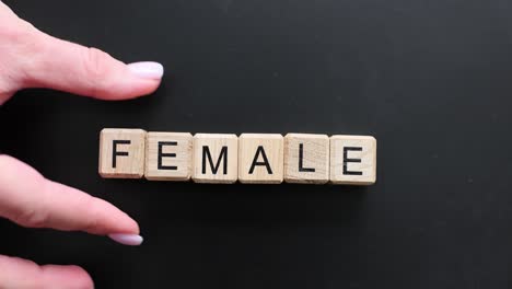 word female spelled out with letter tiles