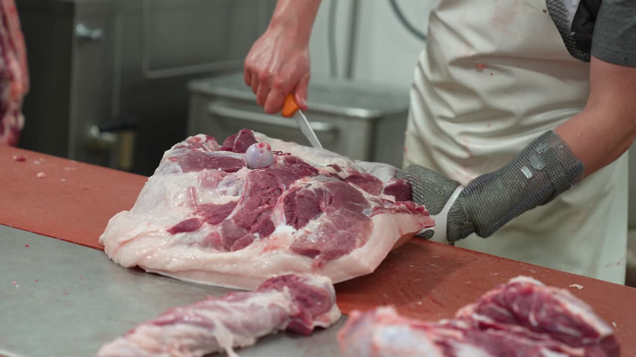 Butcher knife cutting pig flesh from slaughtered animal carcass