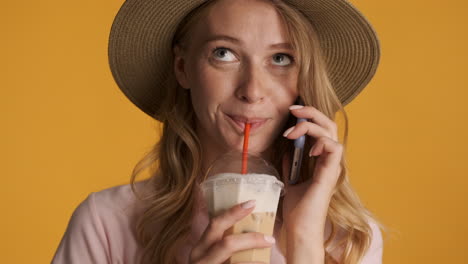 Caucasian-woman-having-phone-call-while-drinking-iced-coffee.