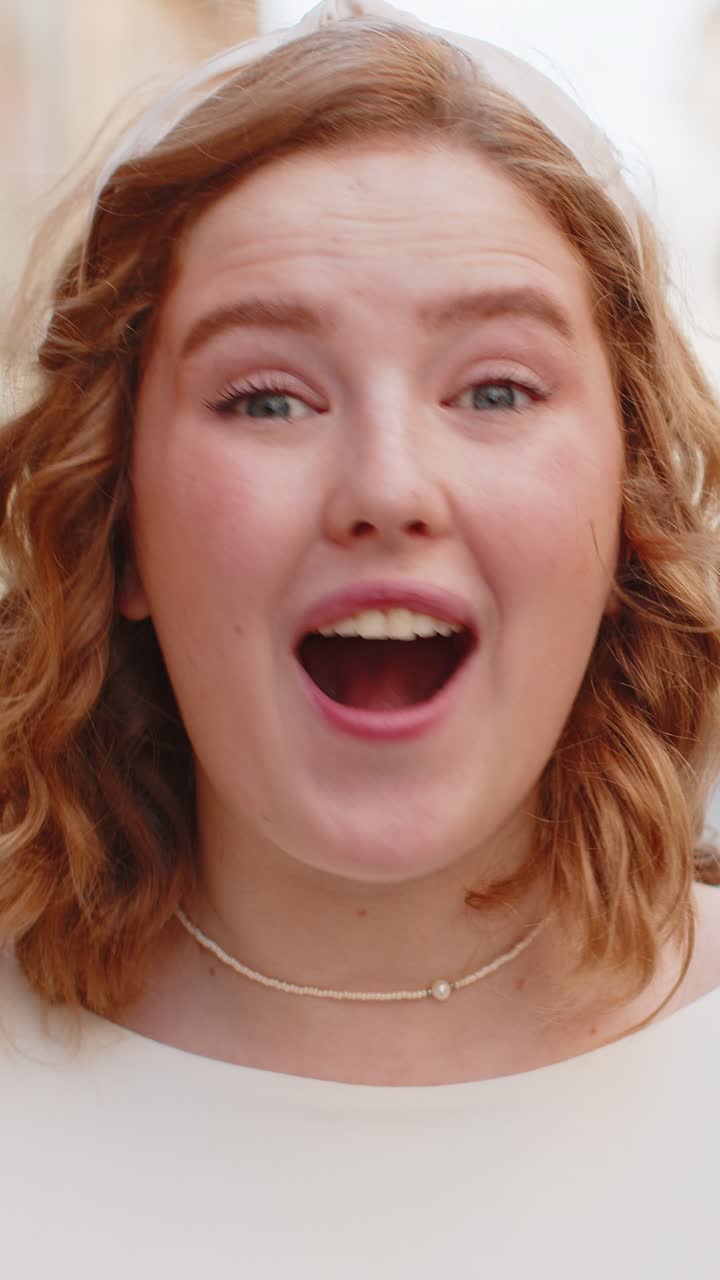 mujer pelirroja mirando sorprendida a la cámara conmocionada por la repentina victoria buenas noticias de victoria wow en la calle de la ciudad