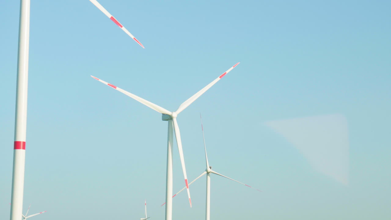 파란 하늘을 배경으로 열차 창문에서 바람 터빈의 전망