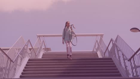 Spots-of-light-against-african-american-man-carrying-his-bicycle-walking-down-the-stairs