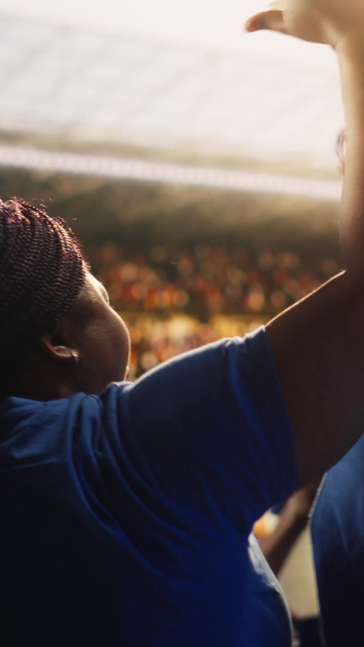 Vertical video Close up of football supporters raising scarves, stadium experience concept