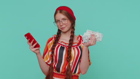chica pelirroja rica con teléfono inteligente regocijándose ganar, recibir dinero en efectivo, éxito lotería suerte