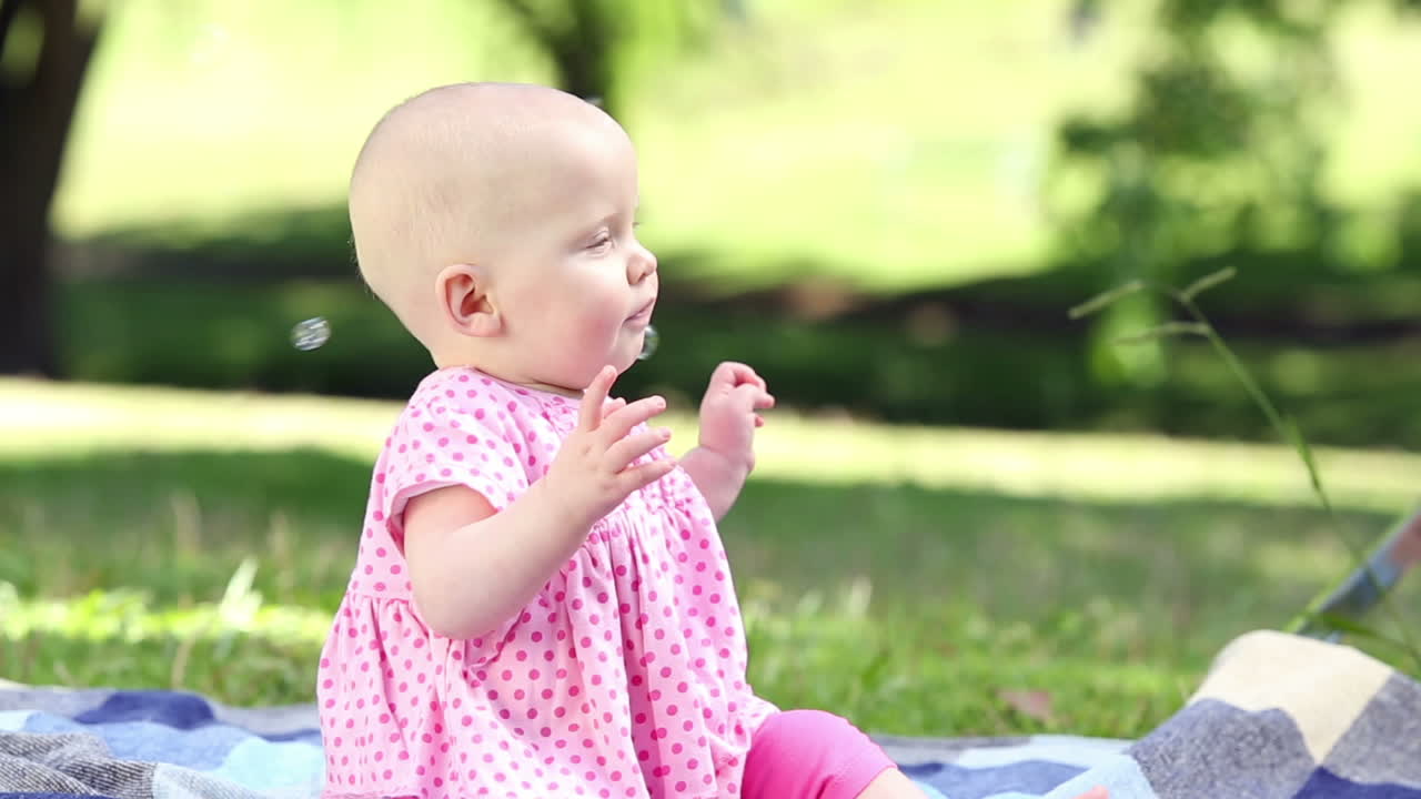 niña jugando con burbujas en el parque