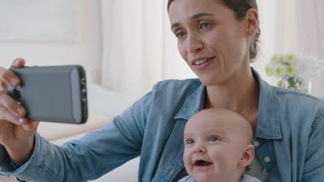 Schöne-Mutter-Und-Baby-Beim-Videochat-Mit-Dem-Smartphone.-Mutter-Teilt-Den-Mutterschaftslebensstil-Und-Hält-Ihr-Kleinkind-In-Der-Hand-Und-Genießt-Die-Mobiltelefonkommunikation-Mit-Der-Familie-Zu-Hause