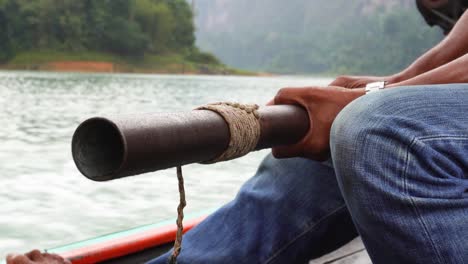 a man is driving a longtail boat in the area of khao sok national park in south thailand